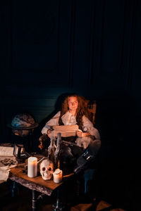 Portrait of young woman sitting on table at home