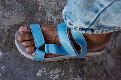 Left foot of an adult wearing a light blue sandal. fashion shoes.