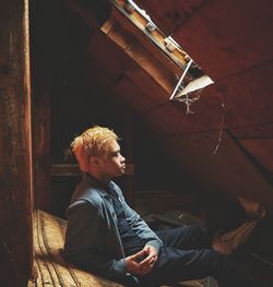 Full length of young man resting against roof