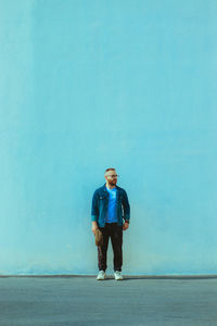 Rear view of man standing at beach against clear sky