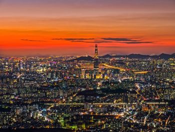 High angle view of illuminated city against sky during sunset