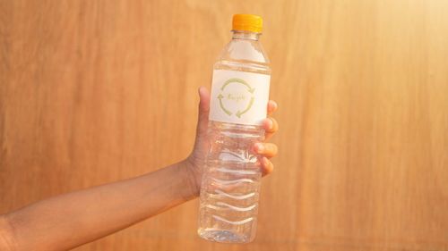 Close-up of hand holding glass bottle