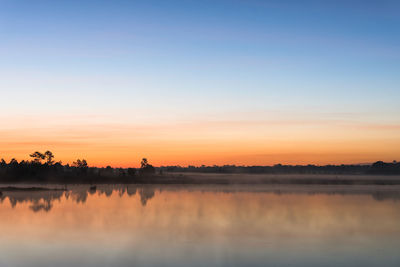 Scenic view of silhouette trees against clear sky during sunset