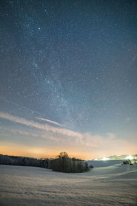 Scenic view of snow against sky at night