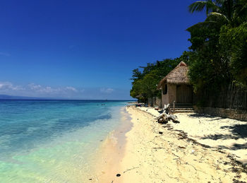 Scenic view of beach against blue sky