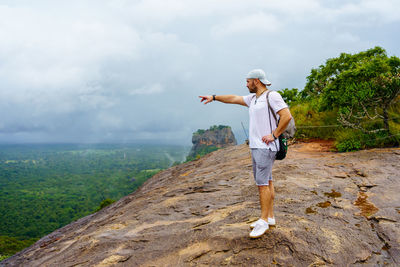 Pidurangala rock. sri lanka. young man shows the direction with his hand.