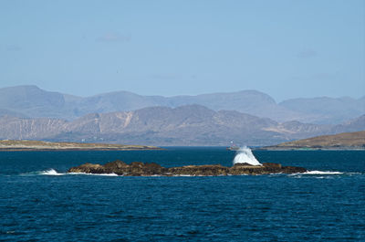 Scenic view of sea and mountains against sky