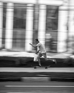 Blurred motion of man skateboarding on road