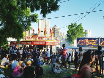 Crowd in city against sky