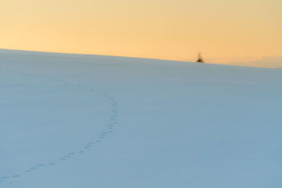 Scenic view of land against clear sky during sunset