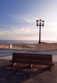 Street light by sea against sky