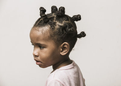 Close-up of girl with hairstyle against white background