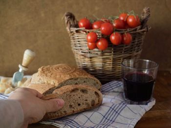 Close-up of hand holding tomatoes in basket