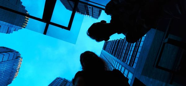 Low angle portrait of man against buildings in city