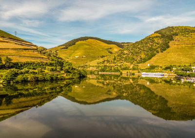 Scenic view of mountains and calm lake against sky