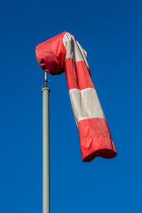 Low angle view of wind sock against blue sky