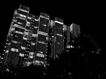 Low angle view of illuminated buildings against sky at night