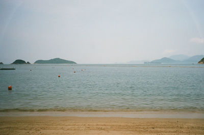 Scenic view of sea with mountain range in background