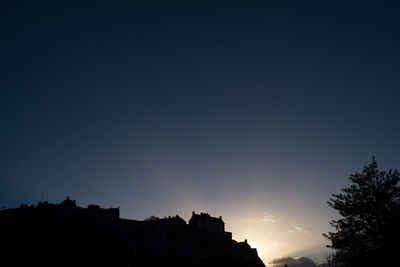 Silhouette of trees against sky at night