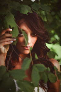 Portrait of young woman holding leaves