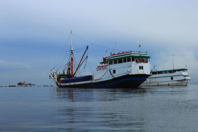 Boat moored on sea against sky