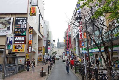 People on street amidst buildings in city