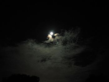 Low angle view of illuminated moon in sky at night