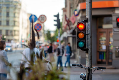 Illuminated road signal with women standing in background