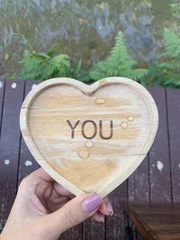 Midsection of woman holding heart shape with text