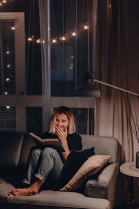 Woman sitting on sofa at home