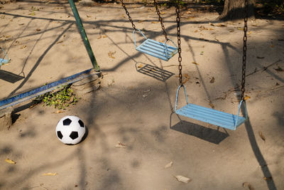 Soccer ball and swings in playground