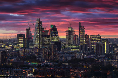 Illuminated cityscape against sky during sunset