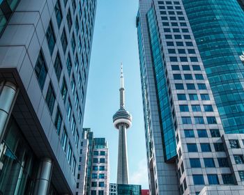 Low angle view of cn tower amidst office buildings