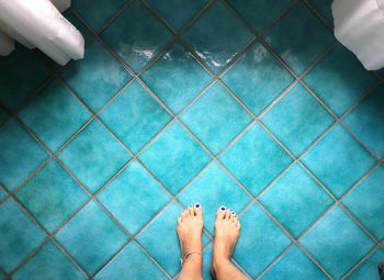 Low section of woman standing on swimming pool