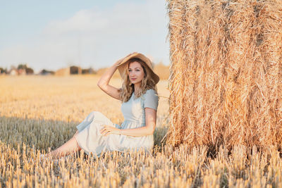 Woman near bales of wheat countryside