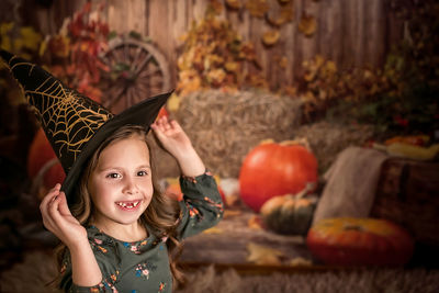 Halloween. a beautiful 6-7-year-old girl tries on a witch hat. he laughs and shows a toothless smile 