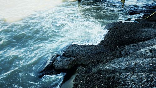 High angle view of waves splashing on rocks