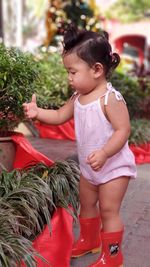 Cute girl looking away while holding plants