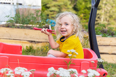 Portrait of cute girl playing with toy car