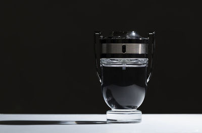 Close-up of drink in glass on table against black background