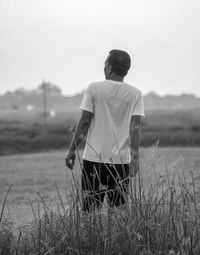 Rear view of man walking on field