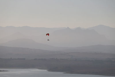 In the early morning mist, a microlight hovers over the bornos reservoir.