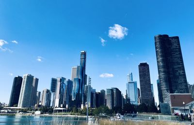 Modern buildings in city against blue sky