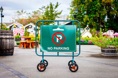 No parking sign on barricade with wheels in park