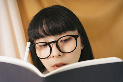 Close-up portrait of young woman with eyeglasses at home