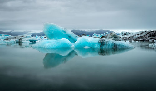 Frozen lake against sky during winter