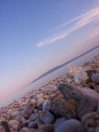 Pebbles on shore against sky