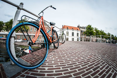 Bicycle parked on footpath against sky