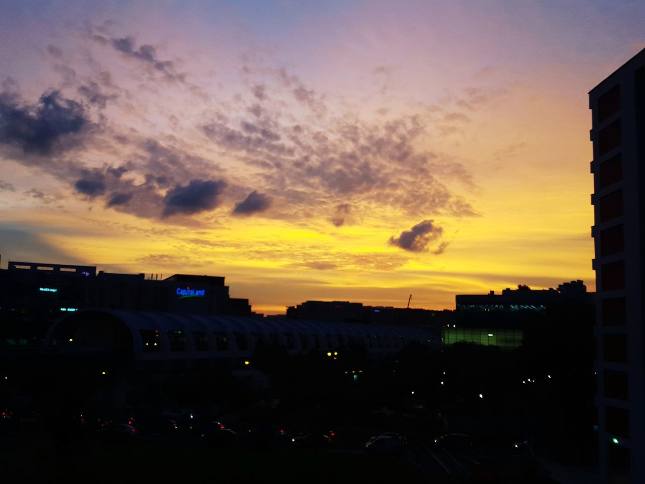 sunset, building exterior, architecture, built structure, sky, city, car, transportation, silhouette, land vehicle, orange color, cloud - sky, mode of transport, dusk, street, illuminated, dramatic sky, city life, outdoors, road