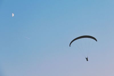 Low angle view of paragliding against clear sky